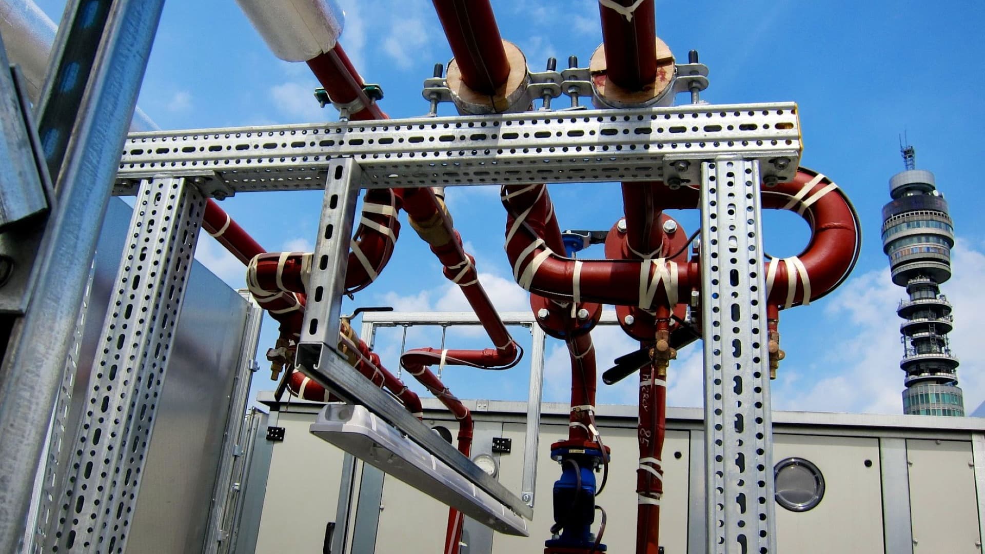 Red pipes with steel brackets in an industrial setup